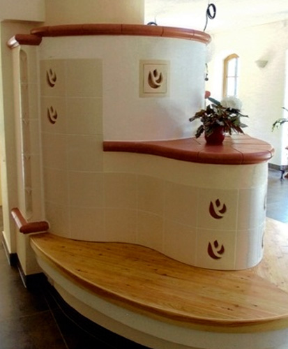 Kachelrundofen mit Holzsitzbank und Kachelelementen in beige und rot