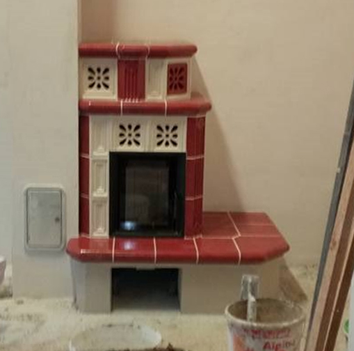 Eck-Warmluft-Speicherofen mit roten Kacheln