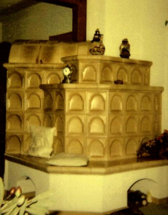 wassergeführter Kachelofen braun und mit Sitzbank