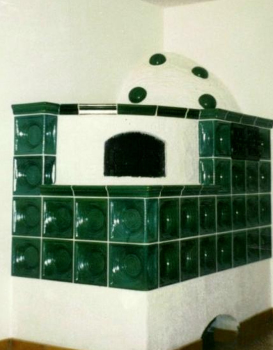 viereckiger wassergeführter Eckkachelofen mit grünen Kacheln