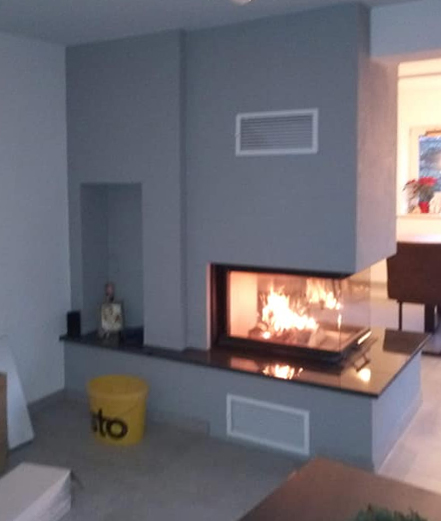 grauer Kaminofen mit Granitplatten