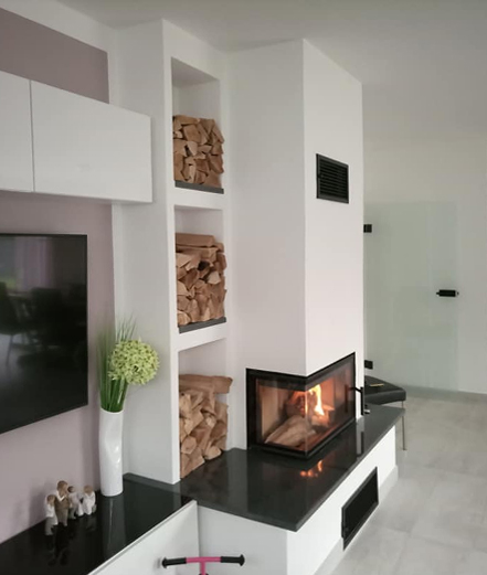 Kaminofen mit schwarzer Granitplatte und seitlicher Holzlagerung