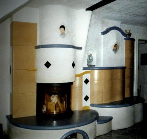 Kachelkamin mit orangenen Kacheln und blauer Auflage