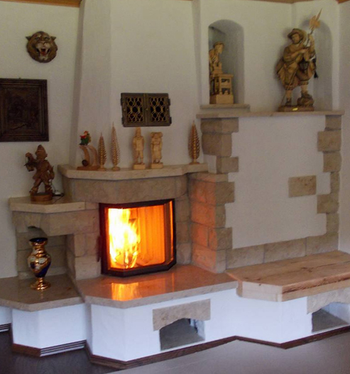 brennender Kamin mit Sandsteinelementen inkulisve Sitzbank