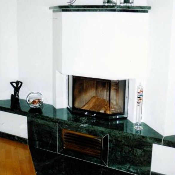 weißer Kamin mit grünlichen Mamor verziert