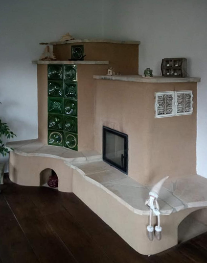 Lehmofen mit grünen Kacheln und Natursteinsitzbank