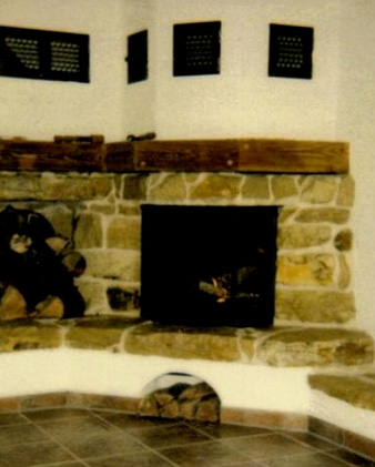 Kamin aus Naturstein mit Holzsims