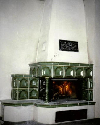 Kachelofen mit grünen Kacheln,
 Säule und Sitzbank