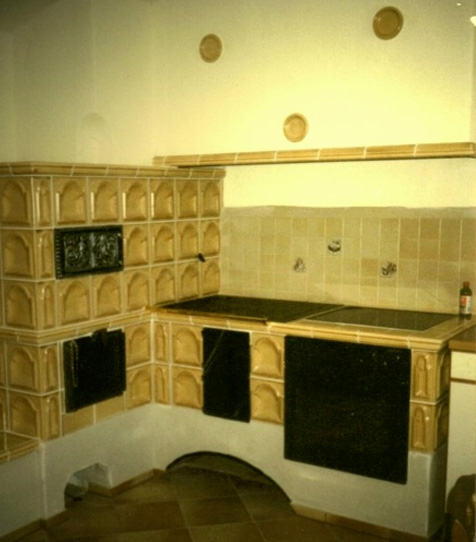 hellbrauner Kachelherd mit modernen Ceranfeld und Einbauherd